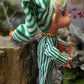 Vintage Christmas elf in green striped pajamas